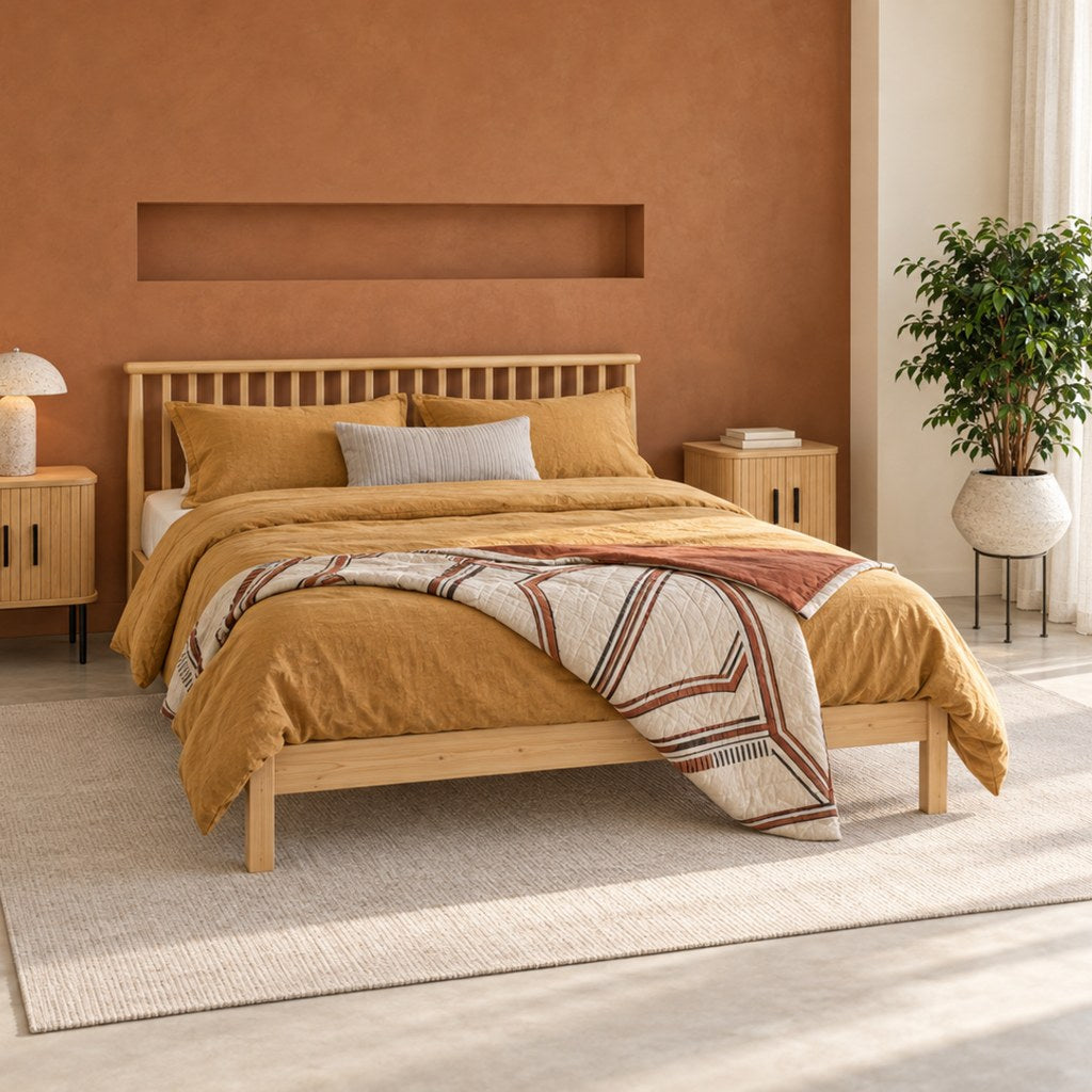 Chambre parentale au mur cannelle, lit en pin clair et linge de lit en lin ocre