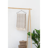 Plaid Bursa Taupe/Beige plié sur un fauteuil en cuir