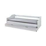 Détail du tiroir du lit en bois blanc, roulettes visibles