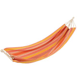Hamac J-Line rayé orange, suspendu dans un jardin verdoyant