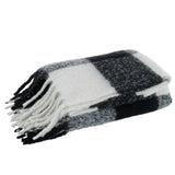 Plaid J-Line drapé sur un canapé moderne, ambiance cosy