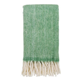 Plaid Carmel en laine verte sur un canapé, texture douce et élégante