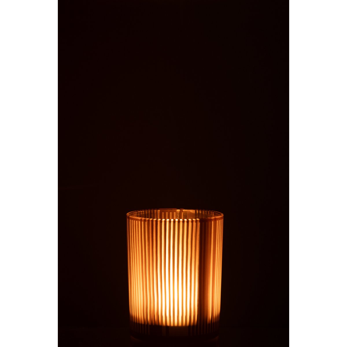 Lanterne J-Line Stripes placée sur une table, créant une ambiance chaleureuse.