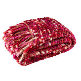 Plaid J-Line Gebreeten drapé sur un canapé, ajoutant une touche de confort.