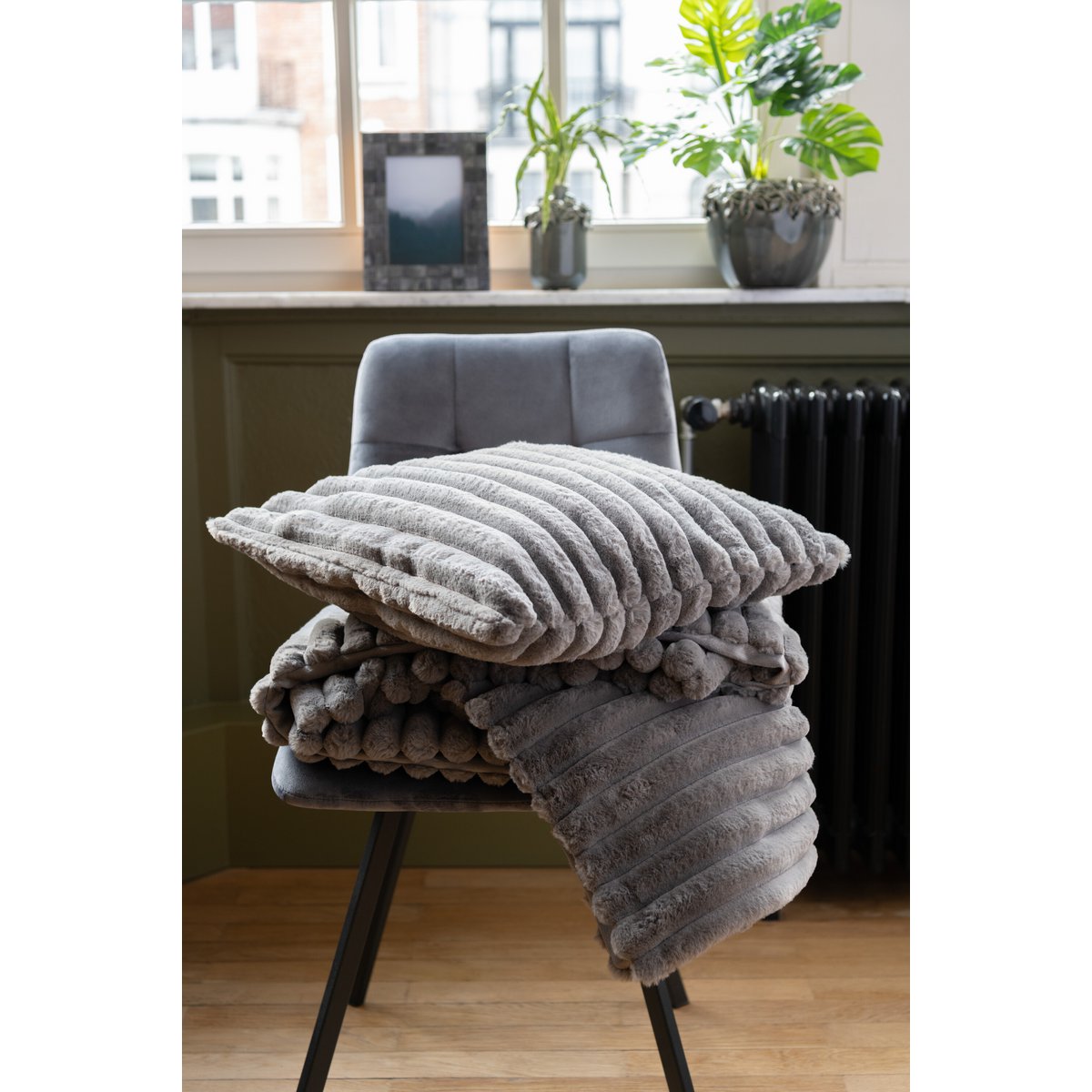 Plaid J-Line gris foncé drapé sur un fauteuil