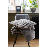 Plaid J-Line gris foncé drapé sur un fauteuil