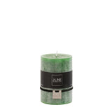 Bougie J-Line vert clair sur table, créant une ambiance chaleureuse
