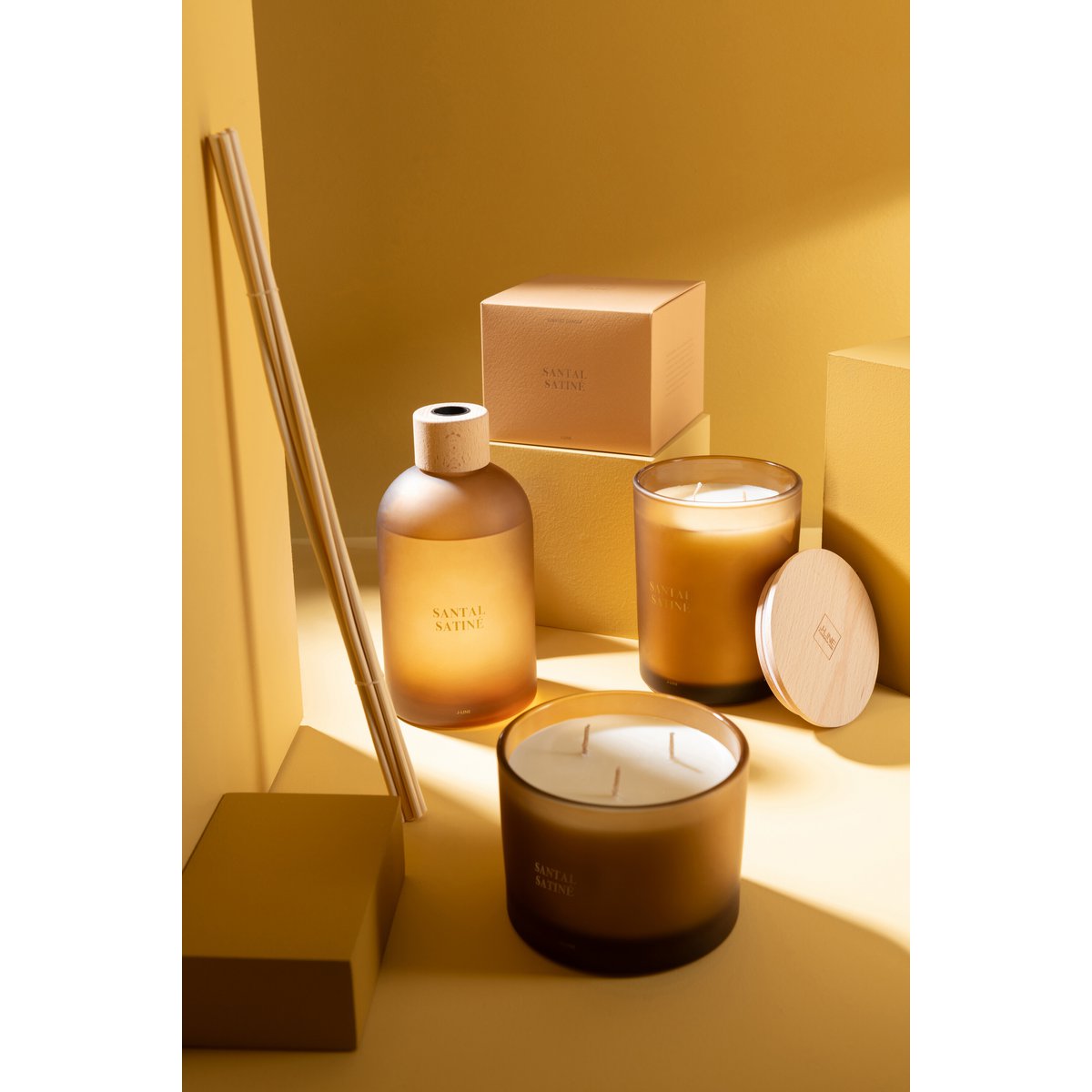 Bougie J-Line Santal Satiné allumée dans un salon