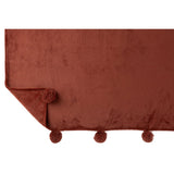 Plaid Pompom rouge marsala drapé sur un canapé