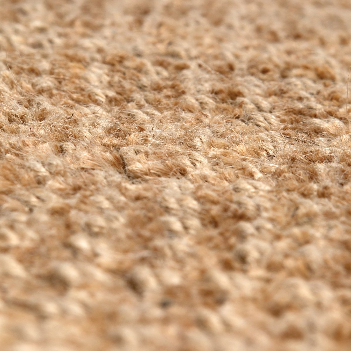 Détail du tapis Elios Naturel en jute, mettant en valeur sa texture et ses couleurs