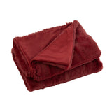 Plaid Cutie J-Line rouge sur canapé, texture douce et luxueuse