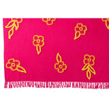Plaid Fleurs de J-Line en coton rose, orange et jaune sur un canapé