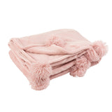 Pompon J-Line sur un lit décoré avec goût