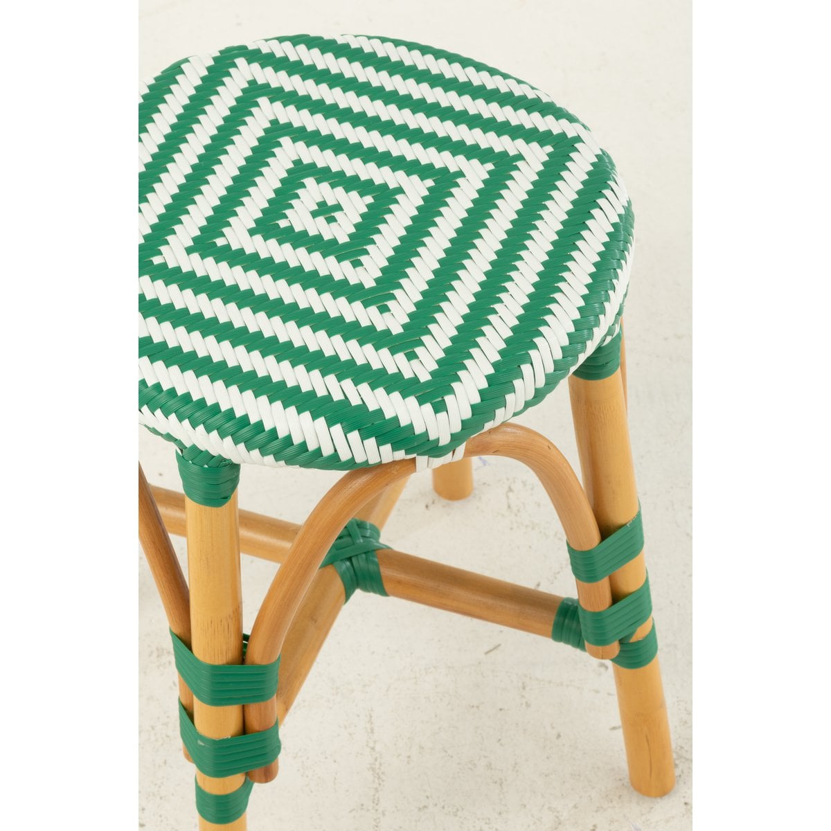 Tabouret J-Line en rotin sur un sol en bois, style boho