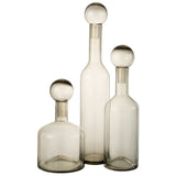 Détail de la bouteille déco Norma en verre gris sur une table moderne