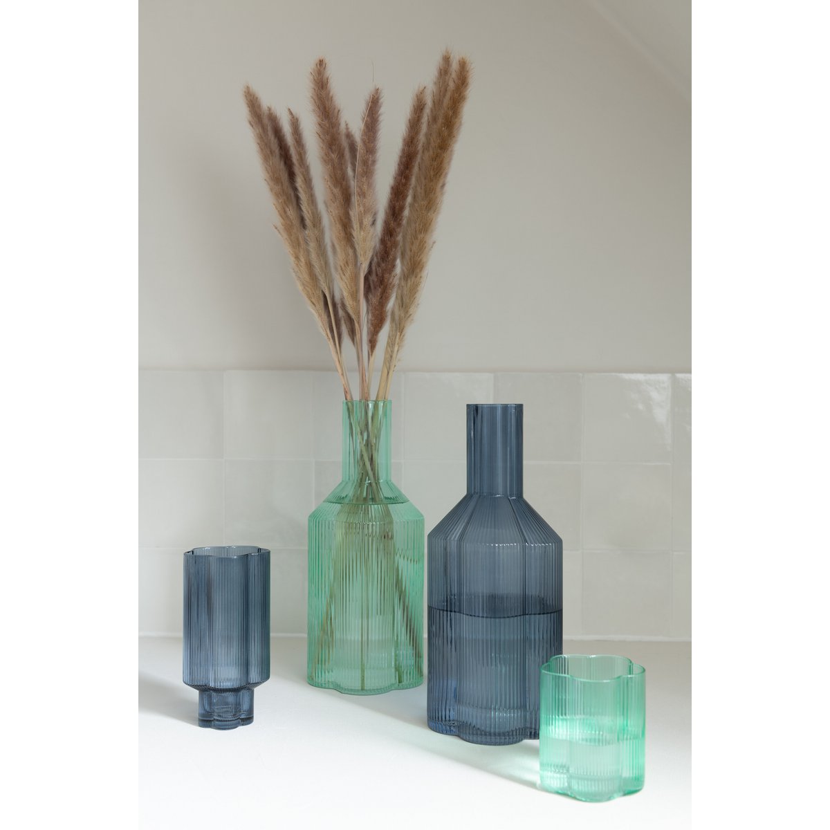 Carafe Fiore J-Line en verre aqua, sur une table élégante
