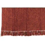 Couverture J-Line en chenille marron, douce et élégante sur un canapé