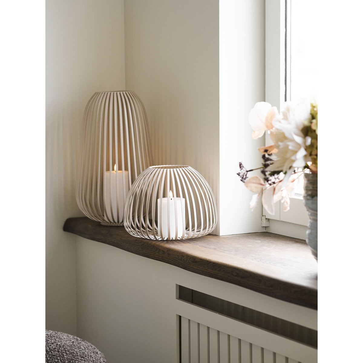 Lanterne Stoense en métal beige, éclairée dans un intérieur moderne