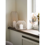 Lanterne Stoense en métal beige, éclairée dans un intérieur moderne