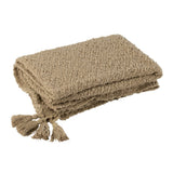 Plaid J-Line en coton beige foncé sur un canapé élégant