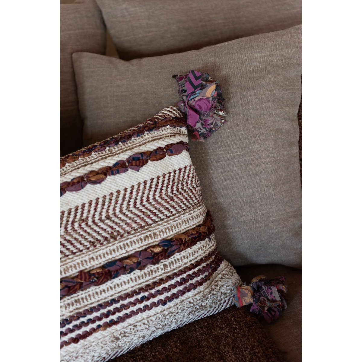 Coussin Chindi sur un canapé, illustrant son intégration dans un décor boho chic.