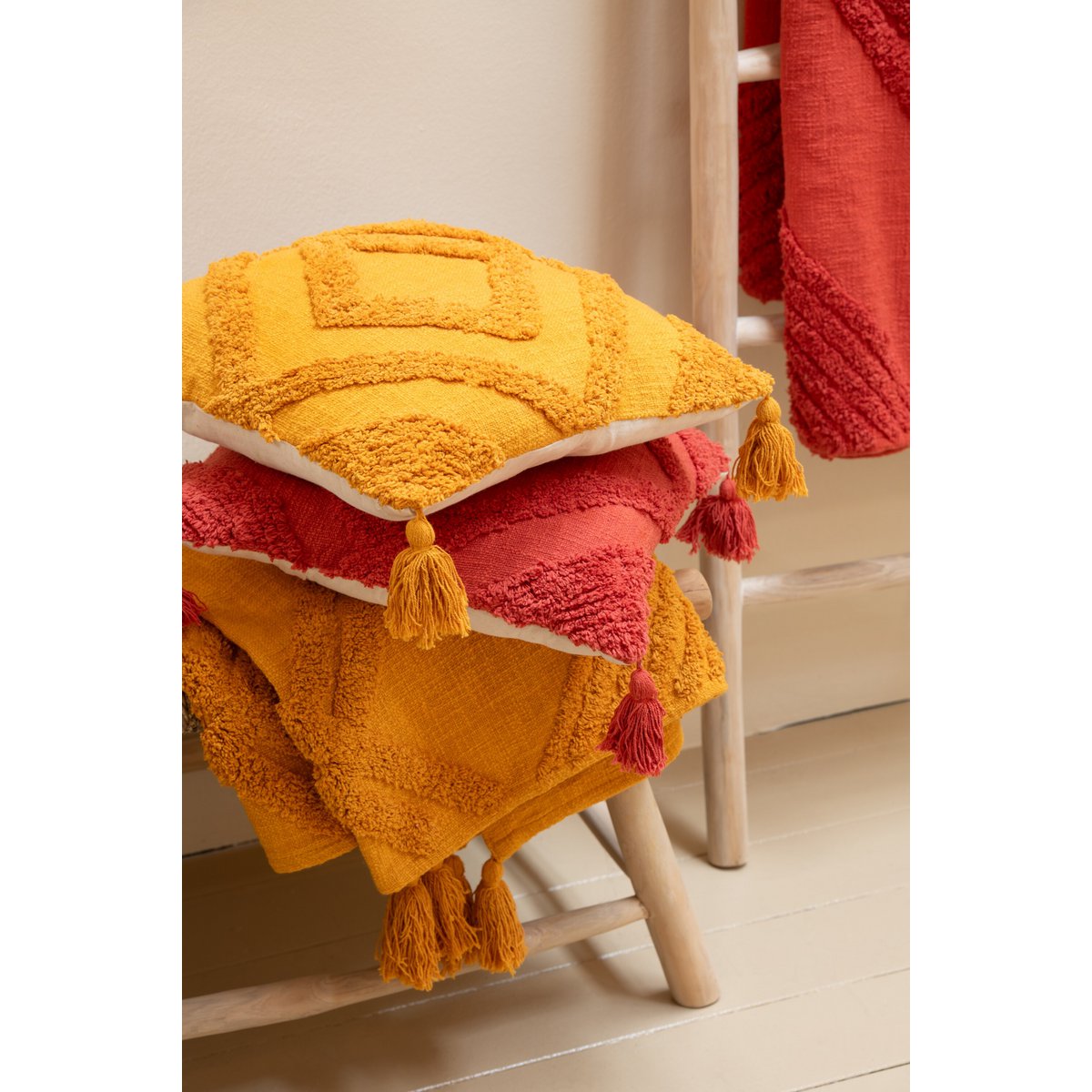 Détail du coussin J-Line en coton ocre, texture tuftée