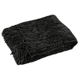 Couverture J-Line en noir, mise en scène sur un canapé moderne.