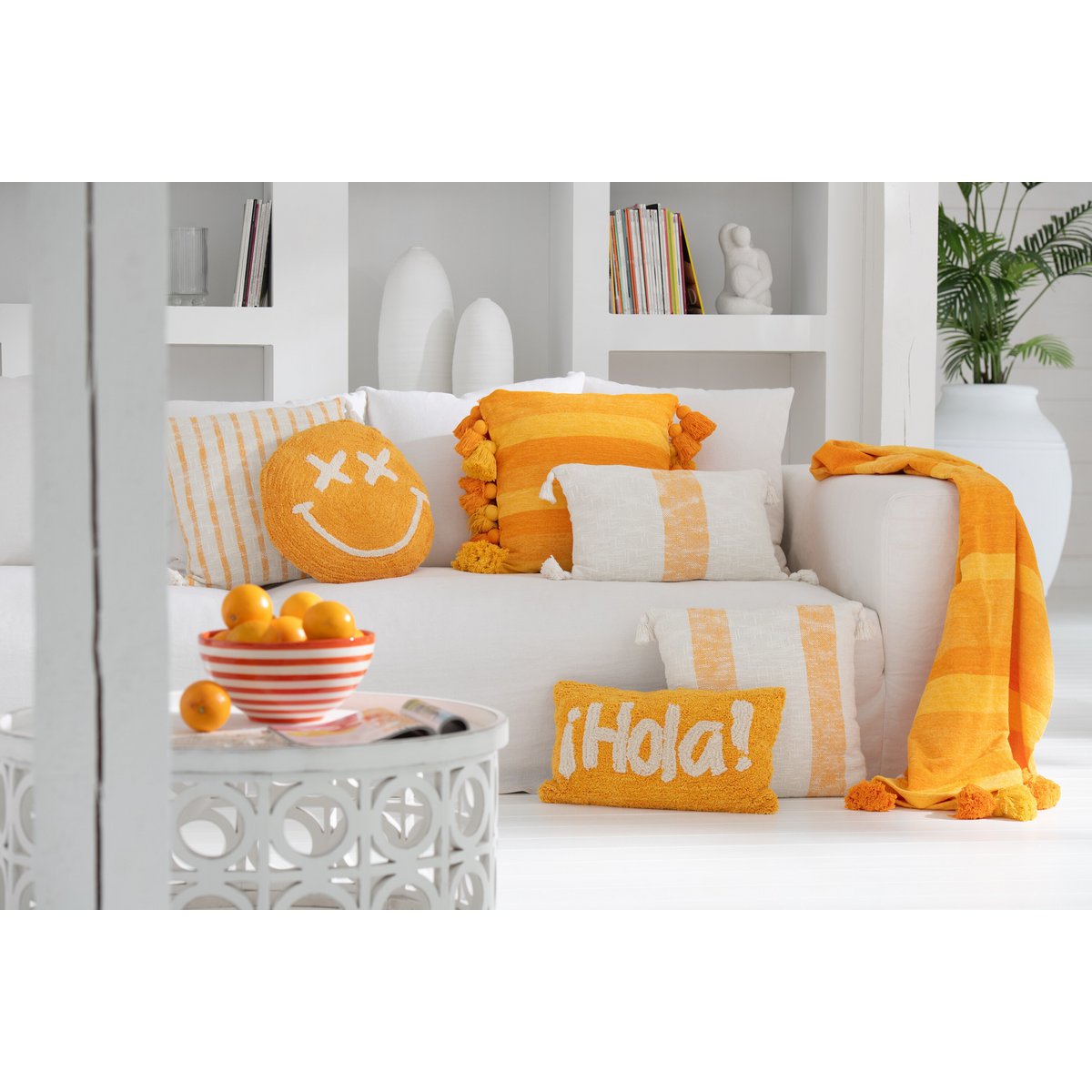 Coussin Smiley J-Line sur un canapé moderne, ambiance chaleureuse.
