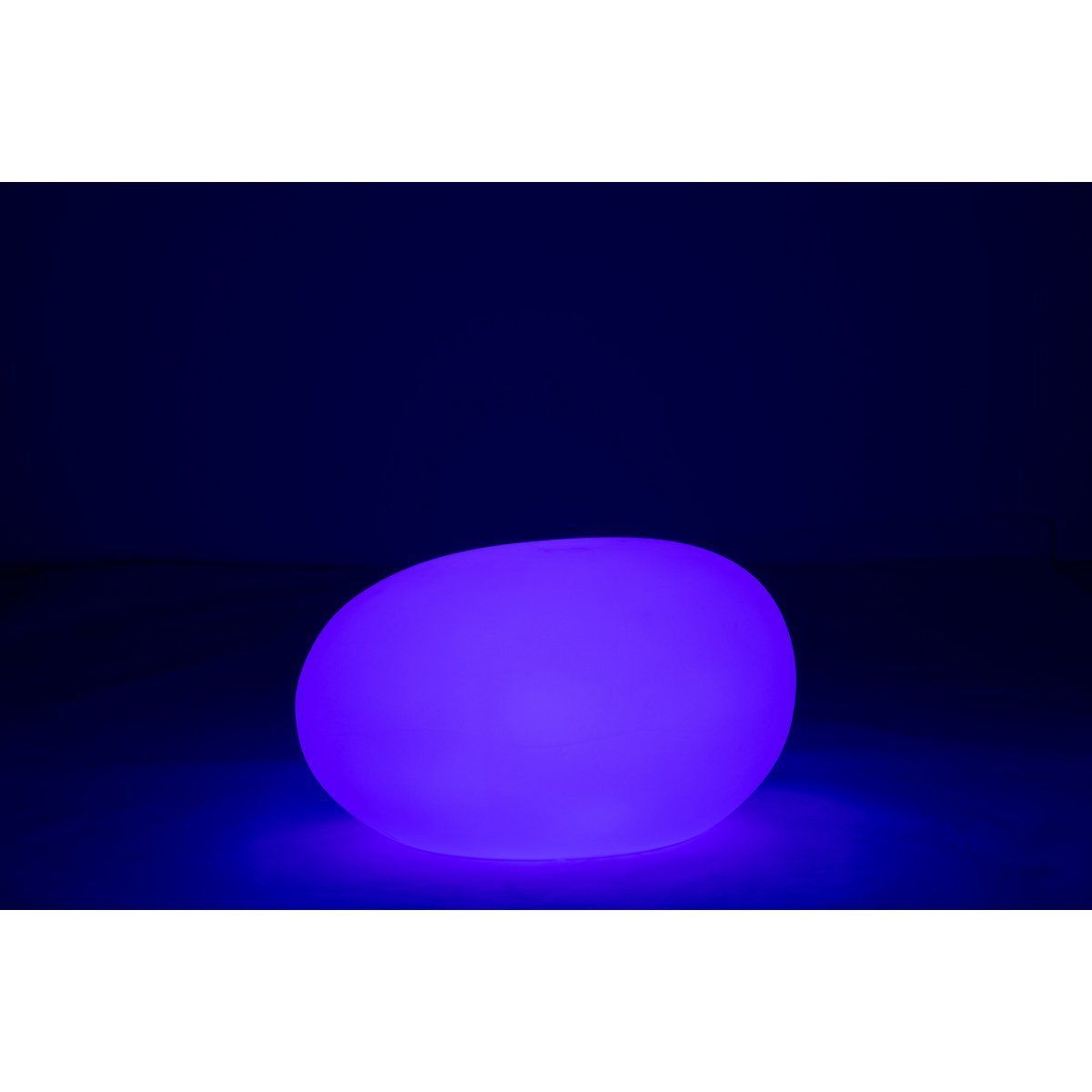 Lampe J-Line posée sur une pelouse, éclairant un chemin