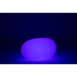 Lampe J-Line posée sur une pelouse, éclairant un chemin
