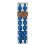 Bougie J-Line Gourd bleue allumée, créant une ambiance chaleureuse dans un salon.