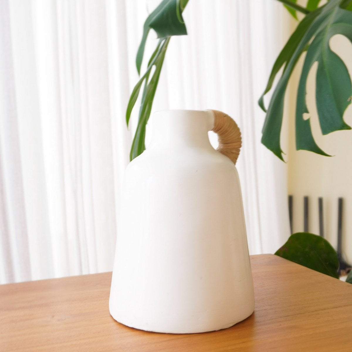 Détail du vase SANA montrant la texture de l'argile et le rotin