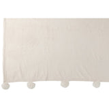 Plaid Pompon crème sur un lit élégant