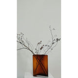 Vase design moderne en ambre, mis en scène dans un intérieur élégant