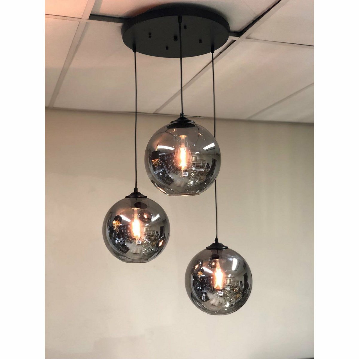 Détail de la lampe suspendue en verre fumé, mettant en valeur les sphères en verre foncé
