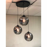 Détail de la lampe suspendue en verre fumé, mettant en valeur les sphères en verre foncé