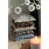 Coussin Tweed J-Line bleu/blanc sur une table décorative