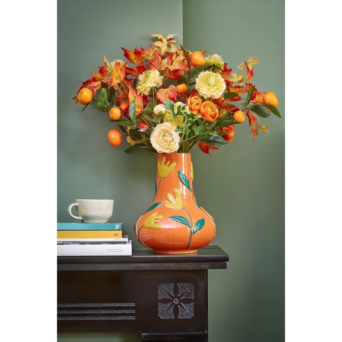 Vase Ava Orange sur une commode, ajoutant une touche de couleur à l'intérieur.