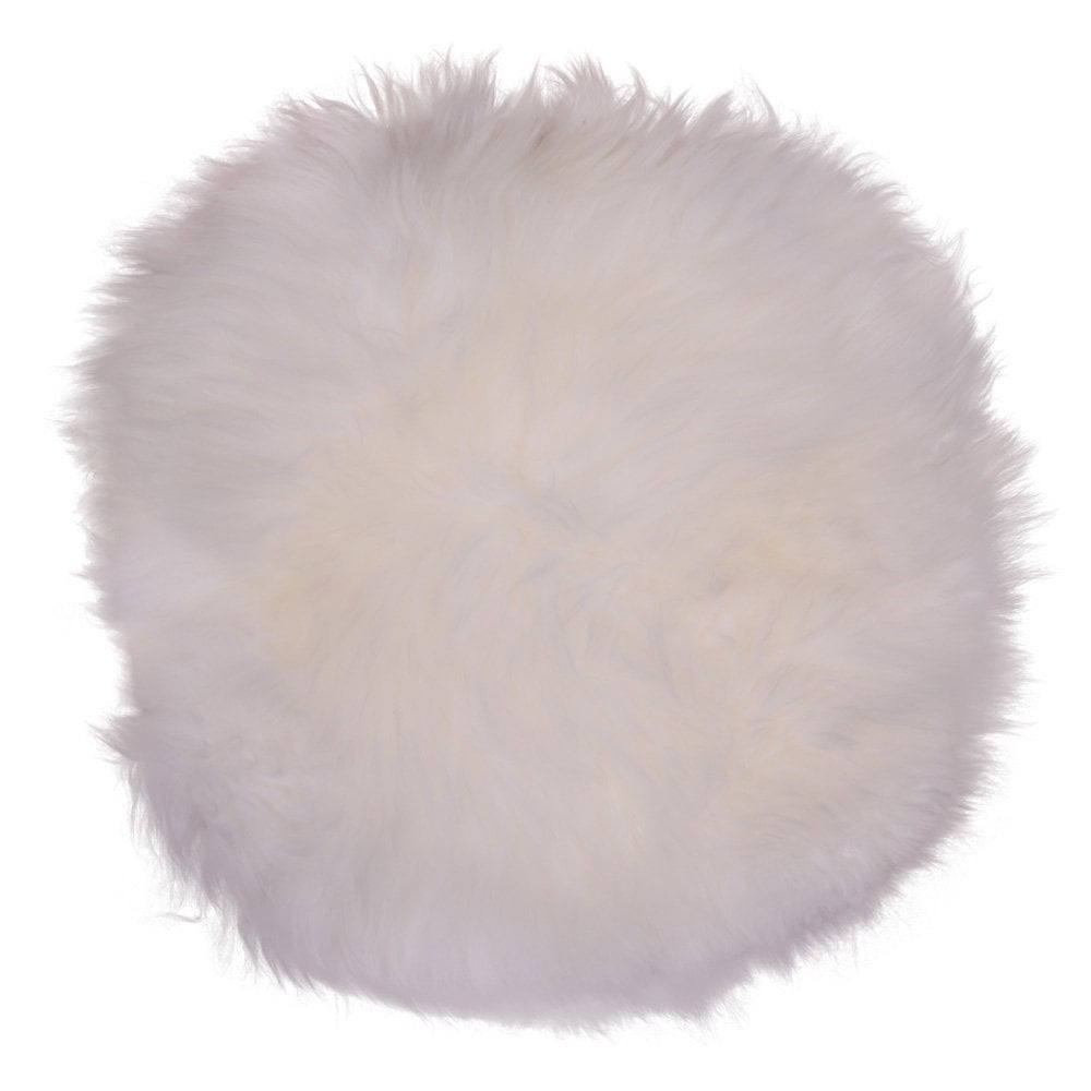 Coussin en peau d'agneau ivoire sur chaise, texture douce et luxueuse