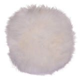 Coussin en peau d'agneau ivoire sur chaise, texture douce et luxueuse