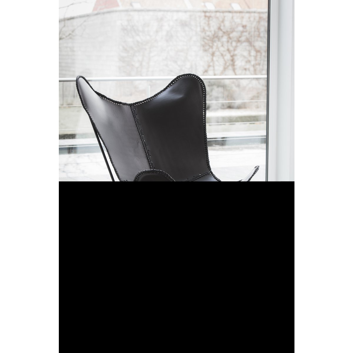 Fauteuil J-Line en cuir noir dans un décor industriel