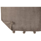Plaid Pompon J-Line drapé sur un fauteuil élégant