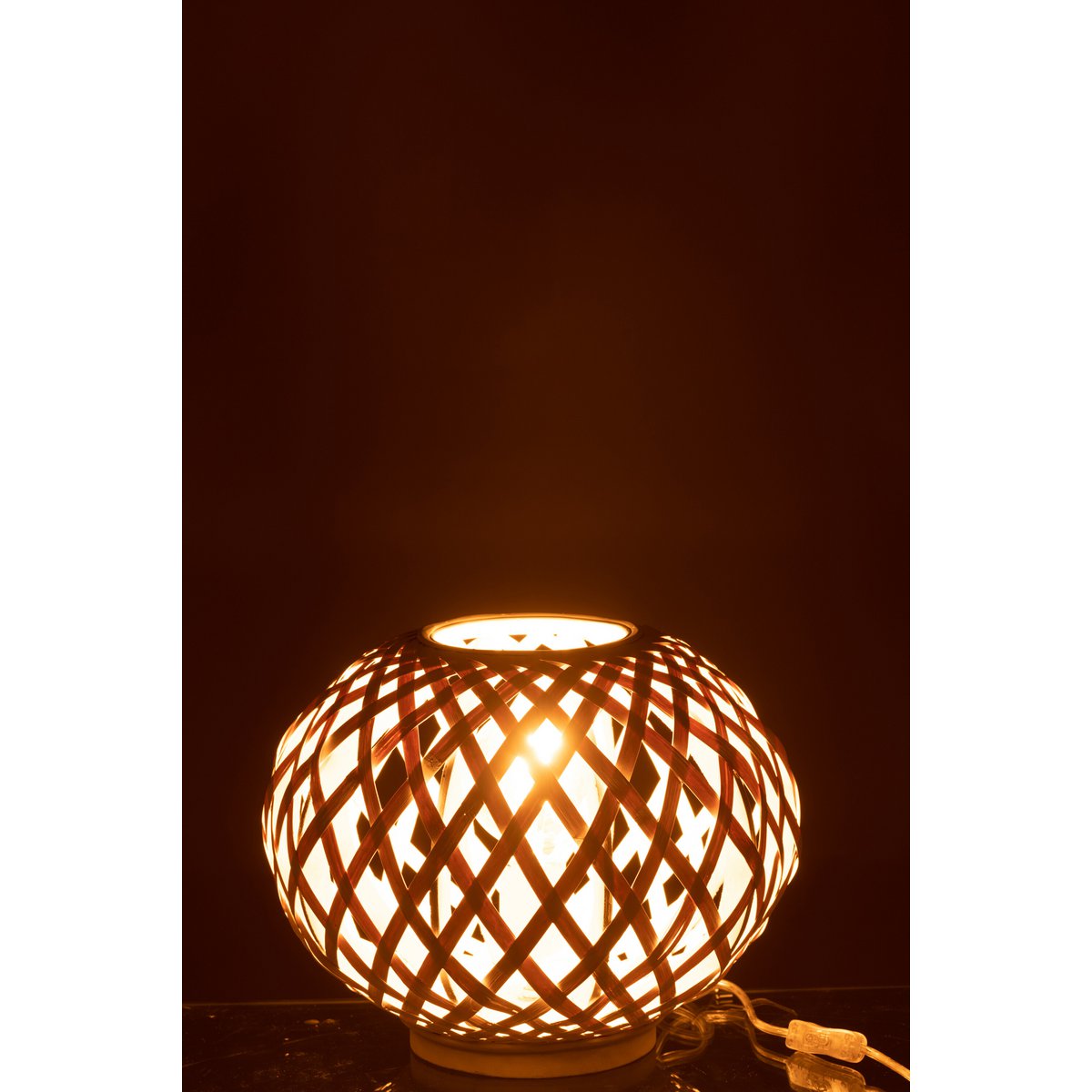 Lampe J-Line en bambou blanc posée sur une table dans un salon