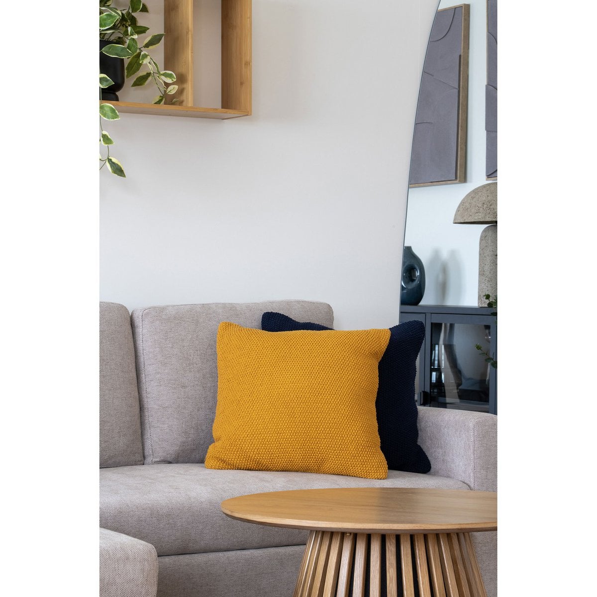 Coussin Santos sur un canapé, ajoutant une touche de couleur ocre