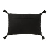 Détail du coussin J-Line en coton noir avec pompons sur un canapé.