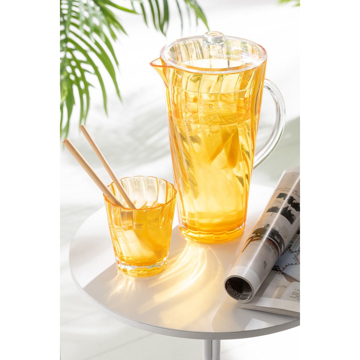 Carafe J-Line Wave en plastique orange sur une table, ajoutant une touche de couleur.
