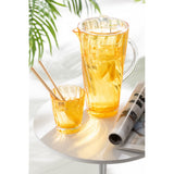 Carafe J-Line Wave en plastique orange sur une table, ajoutant une touche de couleur.