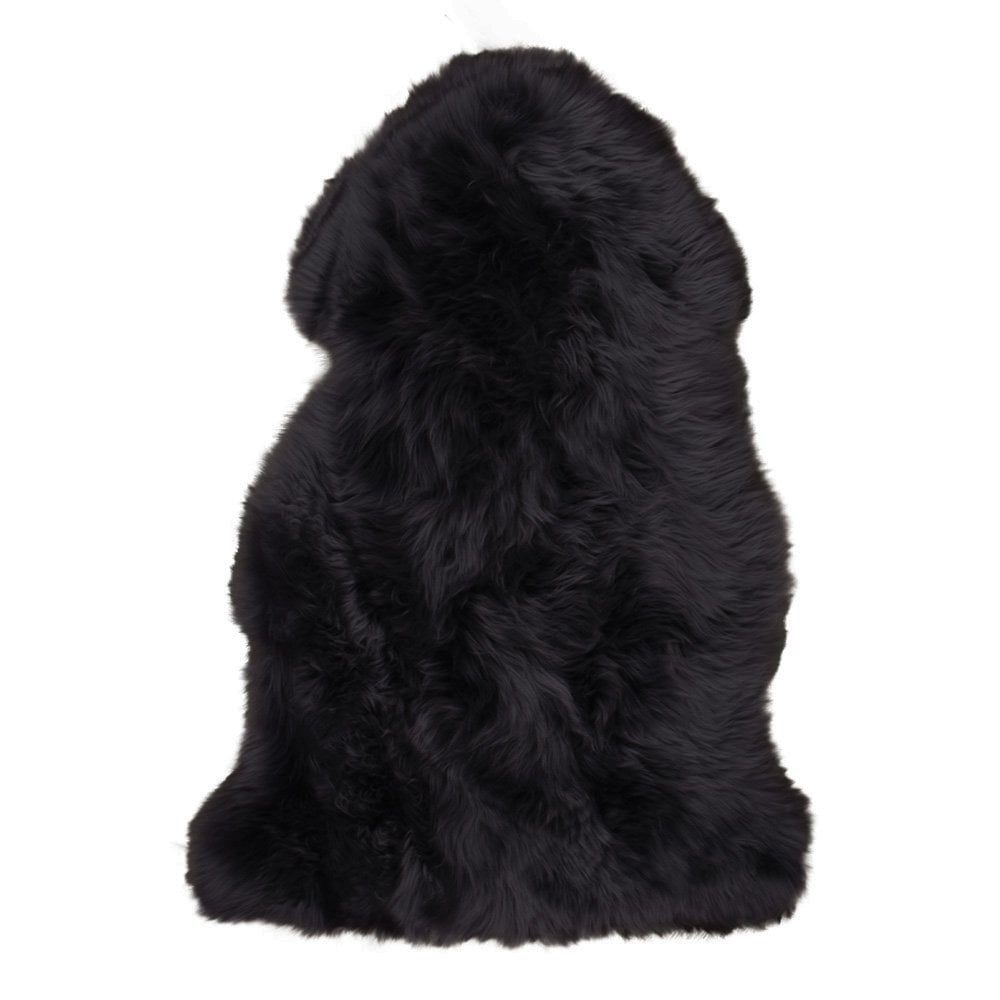 Tapis en peau d'agneau noir sur sol en bois