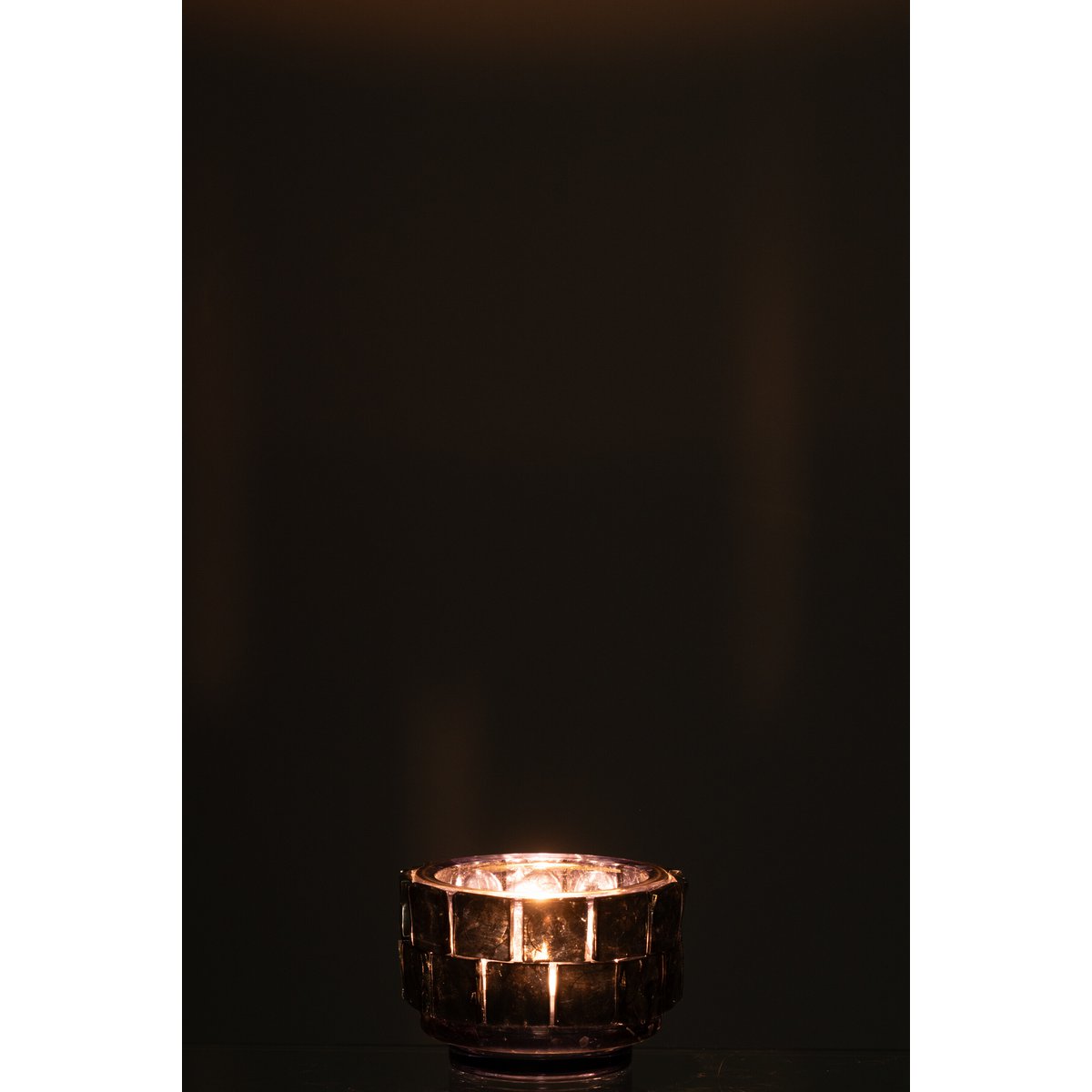 Photophore J-Line en verre bleu foncé, ambiance chaleureuse dans un salon.