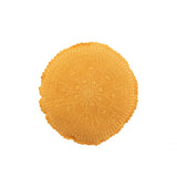 Coussin rond Mia Kant en coton ocre sur un canapé moderne.